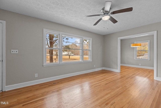 spare room featuring ceiling fan, light hardwood / wood-style floors, and a textured ceiling