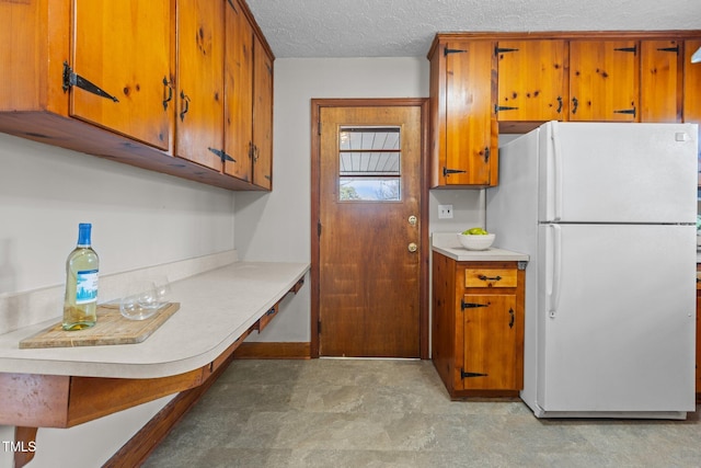 kitchen featuring a textured ceiling and white fridge