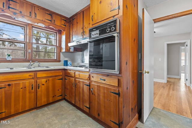 kitchen featuring sink, black oven, white gas cooktop, and a textured ceiling