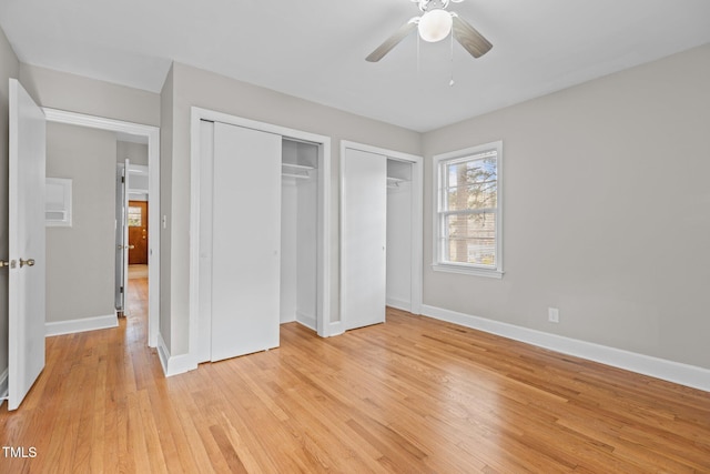 unfurnished bedroom featuring two closets, ceiling fan, and light hardwood / wood-style flooring