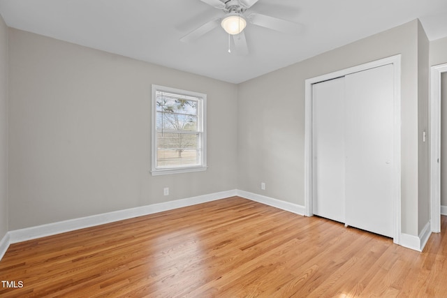 unfurnished bedroom featuring ceiling fan, light wood-type flooring, and a closet