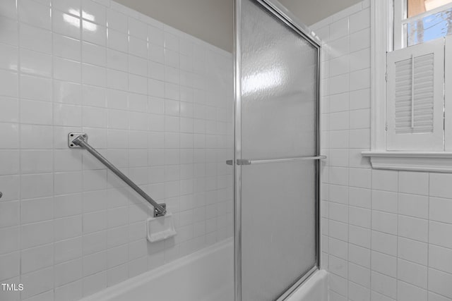 bathroom with bath / shower combo with glass door