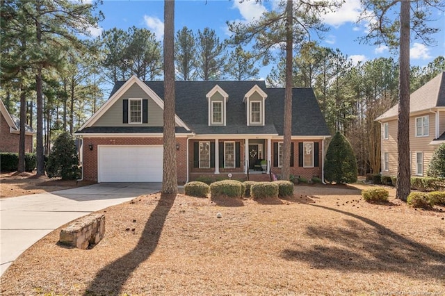 cape cod house with a garage and a porch