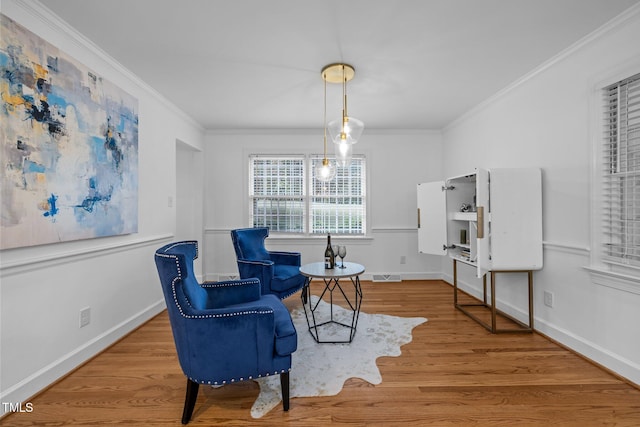 living area featuring crown molding and hardwood / wood-style flooring