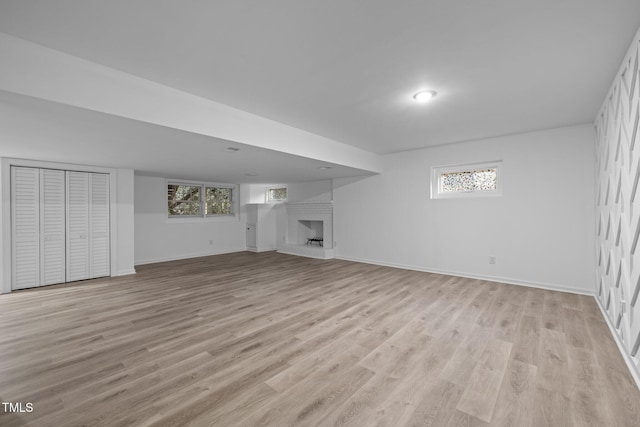 unfurnished living room featuring a large fireplace and light wood-type flooring