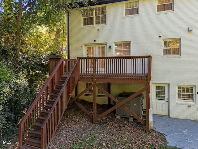 rear view of property featuring a deck and central air condition unit