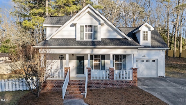 view of front facade featuring covered porch, driveway, a shingled roof, and an attached garage