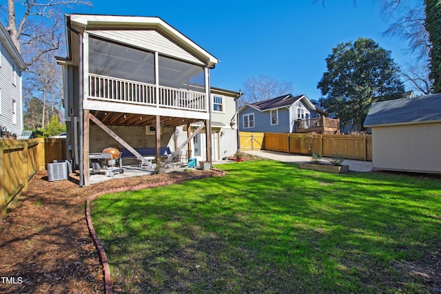 rear view of house featuring a sunroom, a yard, and a patio area