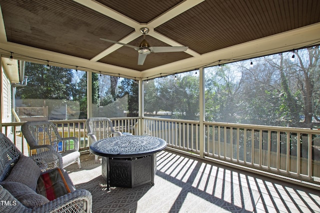 sunroom / solarium with coffered ceiling, ceiling fan, and a healthy amount of sunlight