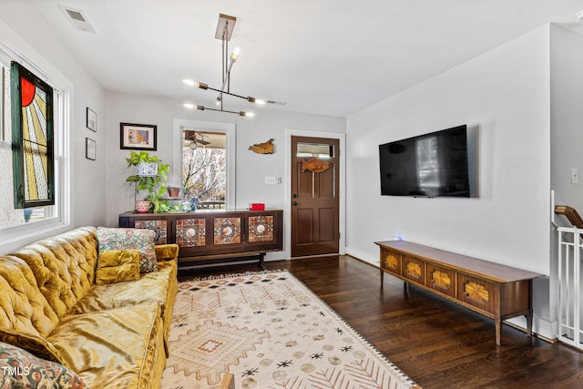 living room featuring a notable chandelier and dark hardwood / wood-style flooring