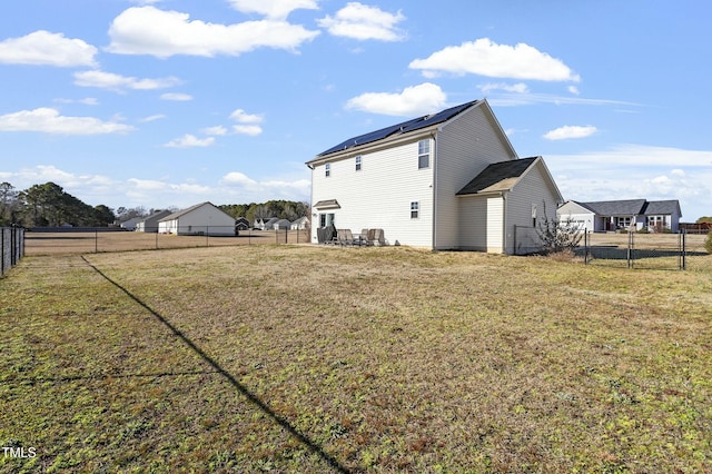 105 Langdon Chase Way, Selma, NC 27576 - rear view of property featuring a fenced backyard, a yard, and roof mounted solar panels