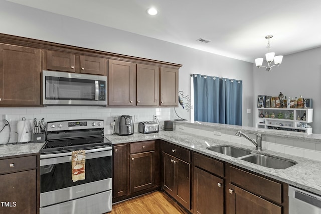 105 Langdon Chase Way, Selma, NC 27576 - kitchen with visible vents, a sink, backsplash, and appliances with stainless steel finishes