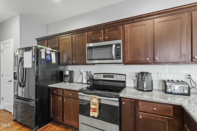 105 Langdon Chase Way, Selma, NC 27576 - kitchen featuring light stone counters, backsplash, light wood-type flooring, and appliances with stainless steel finishes