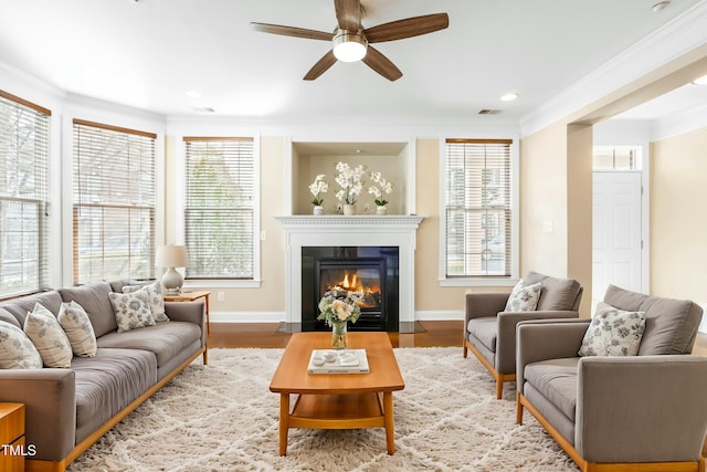 living room with ornamental molding, ceiling fan, and light hardwood / wood-style floors