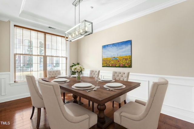 dining area featuring ornamental molding, dark hardwood / wood-style floors, and a tray ceiling