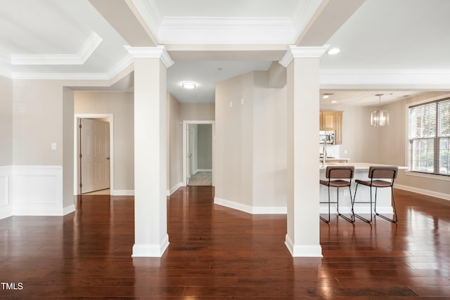 interior space with crown molding, decorative columns, and dark hardwood / wood-style floors