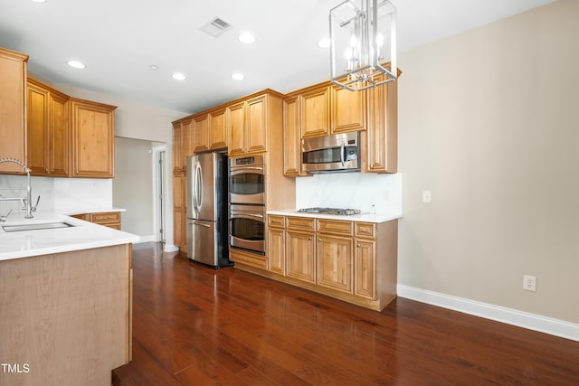 kitchen with sink, tasteful backsplash, dark hardwood / wood-style floors, pendant lighting, and stainless steel appliances