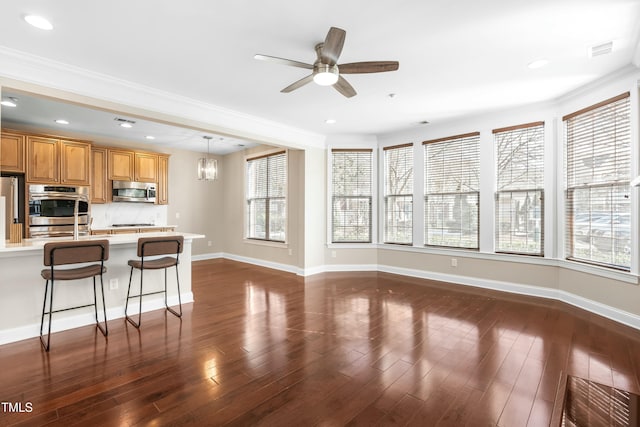 kitchen featuring a healthy amount of sunlight, appliances with stainless steel finishes, a breakfast bar, and hanging light fixtures