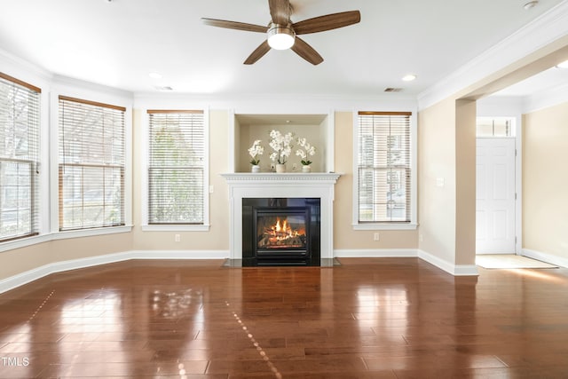 unfurnished living room with crown molding, ceiling fan, dark hardwood / wood-style floors, and a wealth of natural light