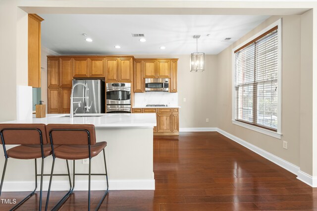 kitchen featuring dark wood-type flooring, stainless steel appliances, a wealth of natural light, decorative backsplash, and kitchen peninsula