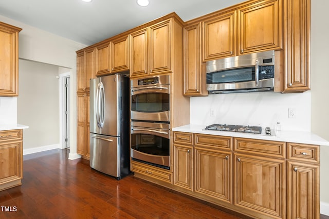 kitchen featuring stainless steel appliances and dark hardwood / wood-style floors