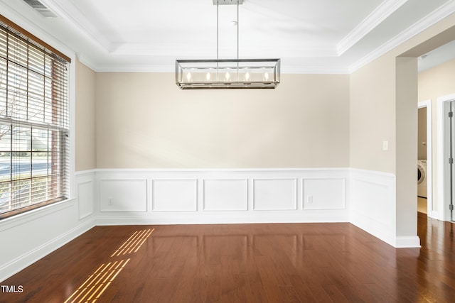 unfurnished dining area with washer / dryer, a wall mounted AC, a chandelier, and a tray ceiling