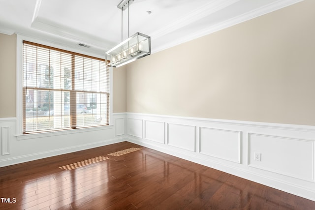 spare room with ornamental molding, dark hardwood / wood-style floors, and a tray ceiling