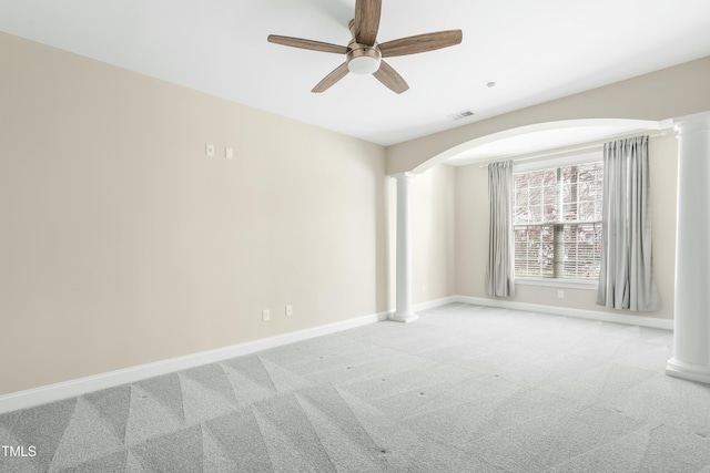 carpeted spare room featuring ceiling fan and decorative columns