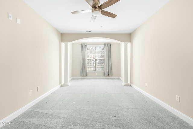 hall with light colored carpet and decorative columns