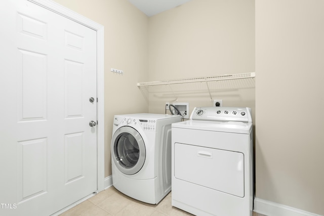 washroom with separate washer and dryer and light tile patterned floors