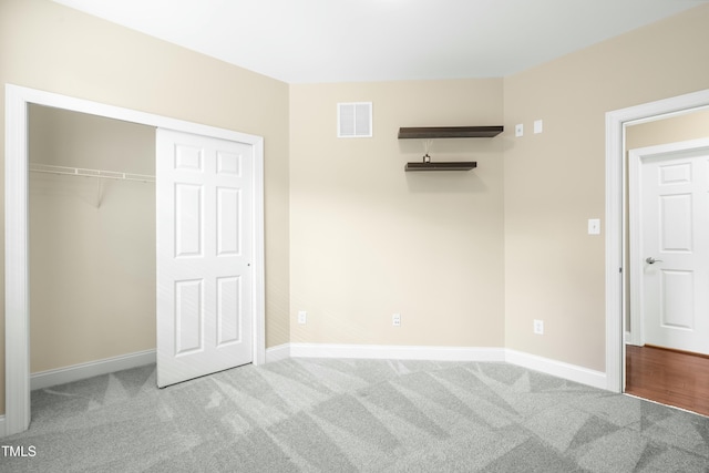 unfurnished bedroom featuring light colored carpet and a closet