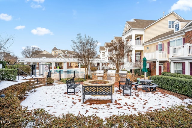 surrounding community with a pergola and a fire pit