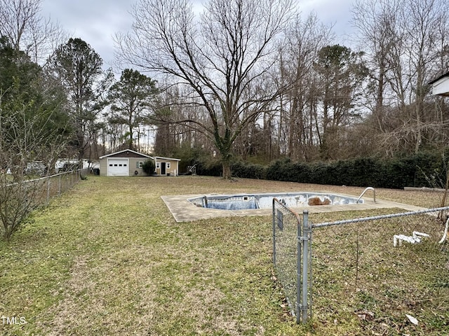 view of yard featuring an empty pool, a garage, and an outdoor structure