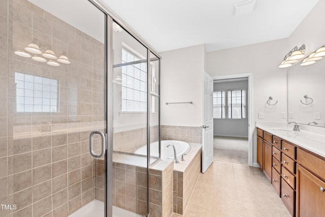 bathroom featuring tile patterned flooring, shower with separate bathtub, and vanity