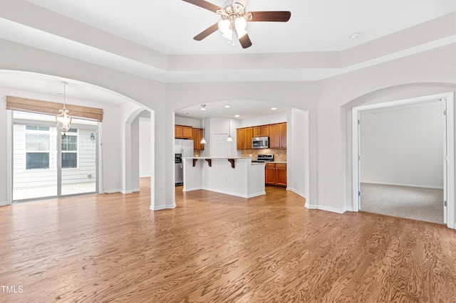 unfurnished living room with ceiling fan and light wood-type flooring