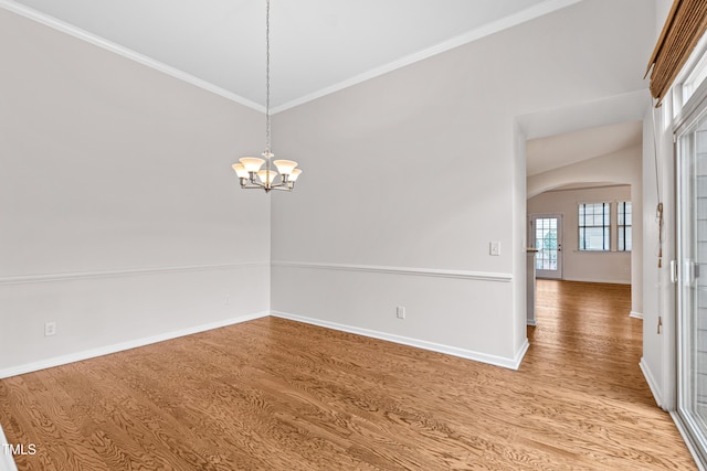 spare room with crown molding, hardwood / wood-style floors, and a chandelier