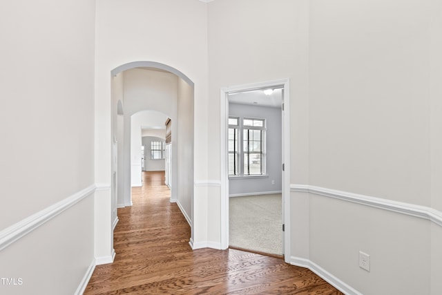 hallway featuring a towering ceiling and wood-type flooring