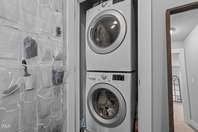 laundry room with stacked washing maching and dryer and carpet flooring