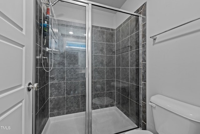 bathroom featuring an enclosed shower and toilet