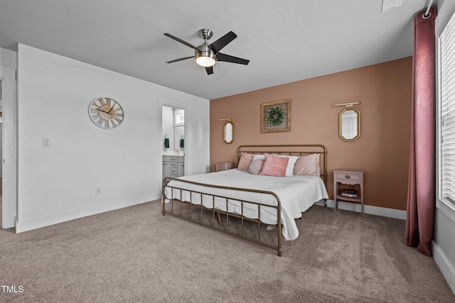 carpeted bedroom with ensuite bath and ceiling fan