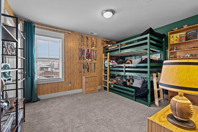 carpeted bedroom featuring wooden walls