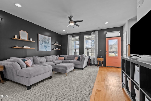 living room featuring ceiling fan and light hardwood / wood-style flooring