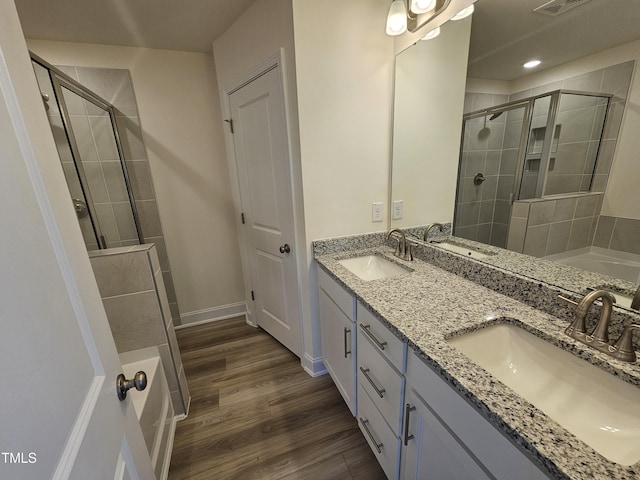 bathroom featuring walk in shower, vanity, and hardwood / wood-style floors