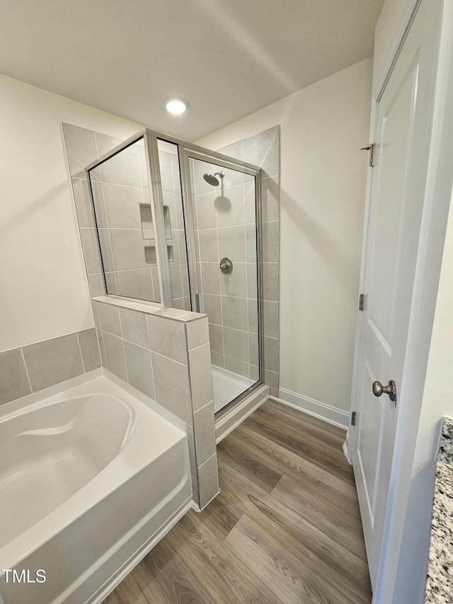 bathroom featuring separate shower and tub and hardwood / wood-style floors