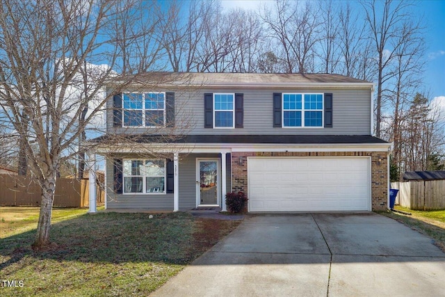 traditional home featuring fence, a front lawn, concrete driveway, and brick siding