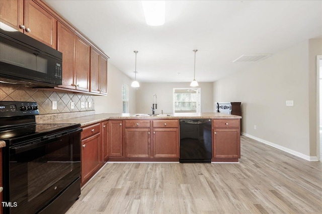 5879 Odenton Ln, Pfafftown, NC 27040 - kitchen featuring black appliances, a sink, light wood finished floors, and a peninsula
