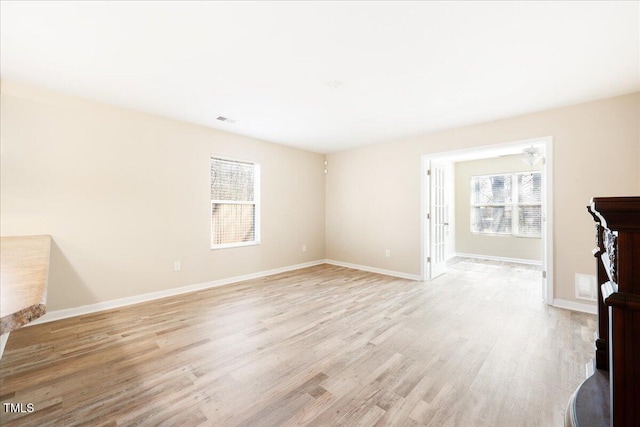 5879 Odenton Ln, Pfafftown, NC 27040 - unfurnished living room featuring healthy amount of natural light, light wood-style flooring, and baseboards