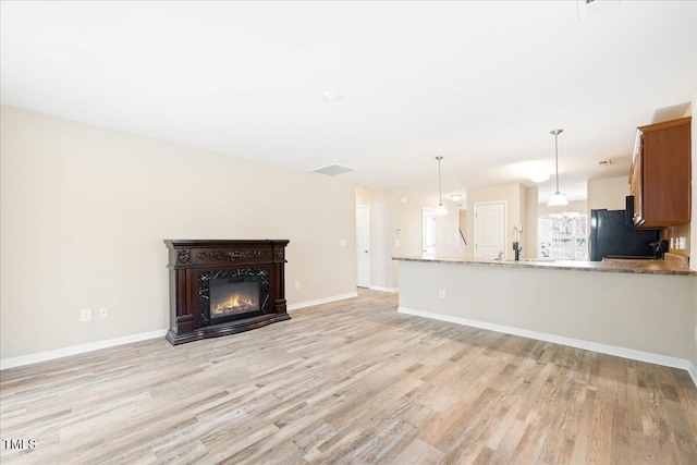 5879 Odenton Ln, Pfafftown, NC 27040 - unfurnished living room with light wood-style floors, baseboards, and a glass covered fireplace
