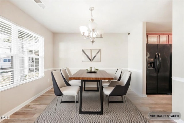 5879 Odenton Ln, Pfafftown, NC 27040 - dining space featuring a chandelier, light wood-style floors, and baseboards