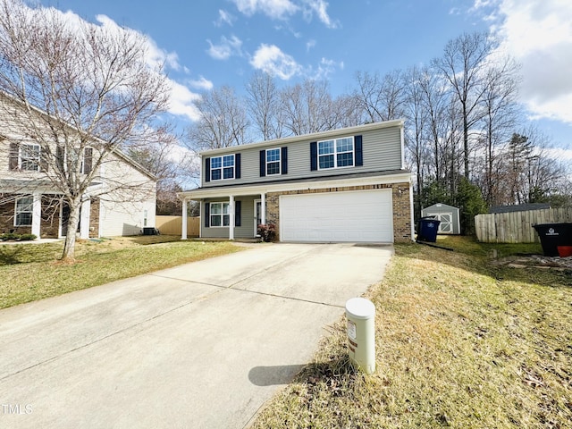 traditional-style home featuring brick siding, concrete driveway, an attached garage, fence, and a front lawn